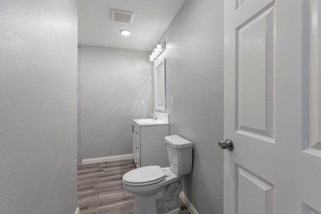 bathroom with vanity, hardwood / wood-style flooring, and toilet