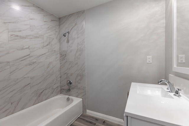 bathroom featuring hardwood / wood-style floors, vanity, and tiled shower / bath combo