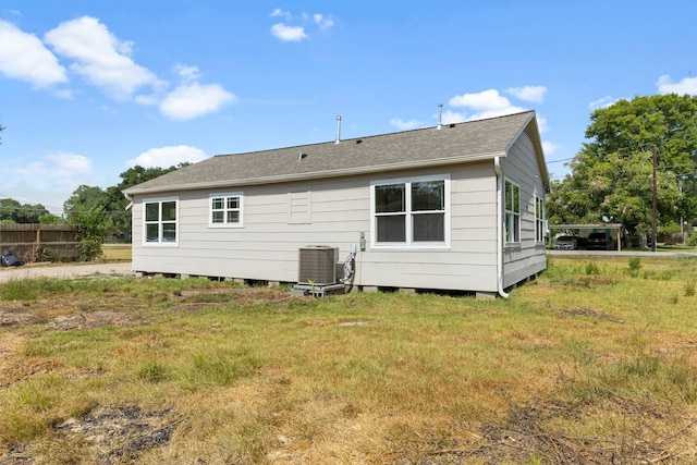 rear view of house featuring a lawn and cooling unit