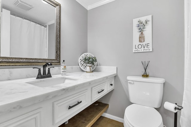 bathroom featuring tile patterned floors, crown molding, vanity, and toilet