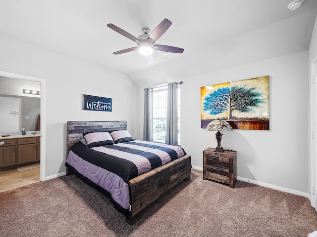 bedroom featuring lofted ceiling, ensuite bath, light colored carpet, and ceiling fan