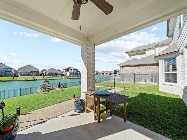 view of patio with ceiling fan and a water view