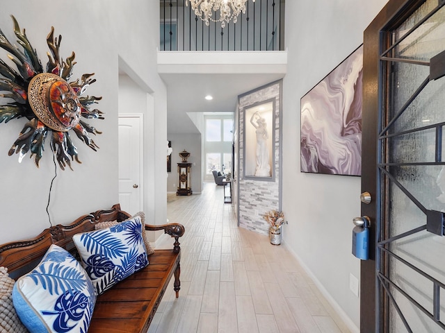 foyer featuring a high ceiling, a notable chandelier, and light hardwood / wood-style floors