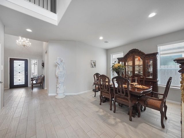 dining space featuring light hardwood / wood-style flooring, plenty of natural light, and an inviting chandelier