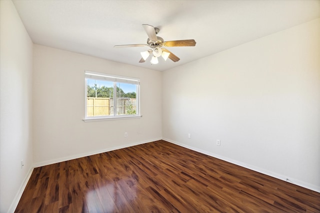 spare room with dark hardwood / wood-style flooring and ceiling fan