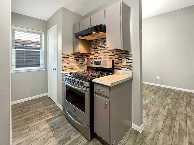 kitchen featuring gray cabinets, decorative backsplash, gas stove, and light hardwood / wood-style flooring