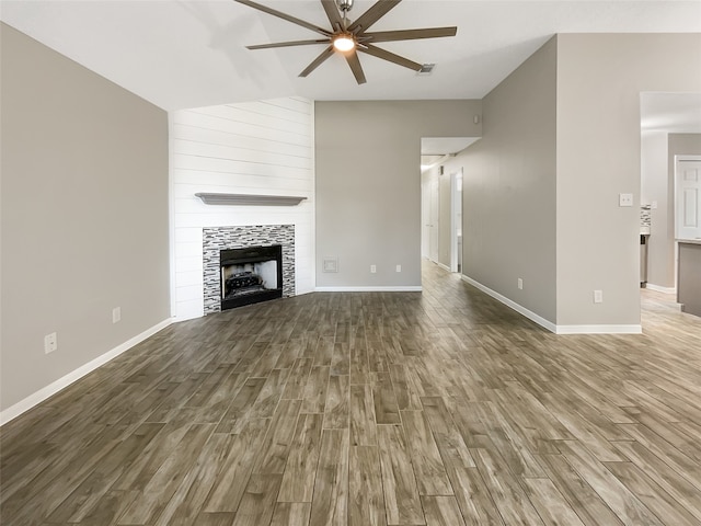 unfurnished living room featuring a tile fireplace, ceiling fan, and hardwood / wood-style flooring