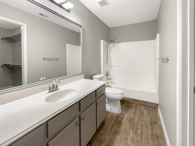 full bathroom with vanity, toilet, wood-type flooring, and tub / shower combination