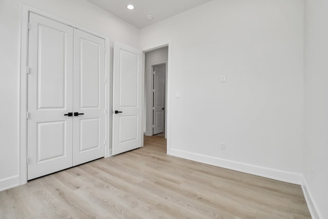 unfurnished bedroom featuring a closet and light hardwood / wood-style flooring