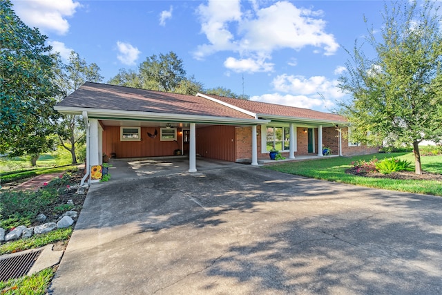 ranch-style home featuring a carport and a front lawn