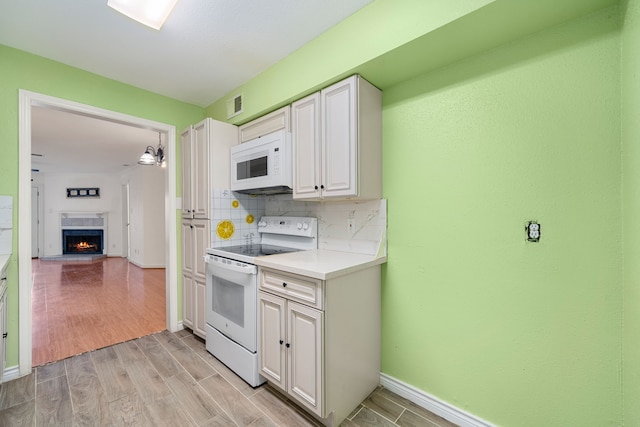 kitchen featuring light hardwood / wood-style floors, white cabinetry, white appliances, and tasteful backsplash