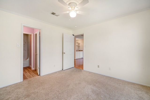 unfurnished bedroom featuring connected bathroom, ceiling fan, crown molding, and light colored carpet