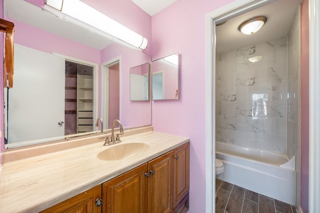 full bathroom with vanity, toilet, and tiled shower / bath