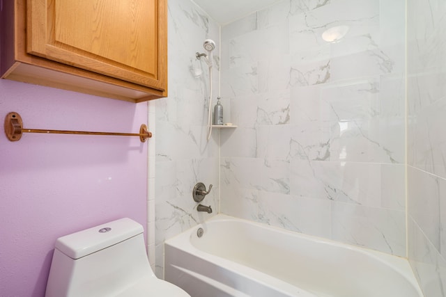 bathroom with tiled shower / bath combo and toilet