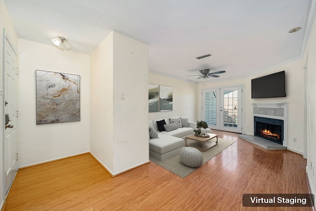 living room featuring ceiling fan, hardwood / wood-style floors, french doors, and ornamental molding