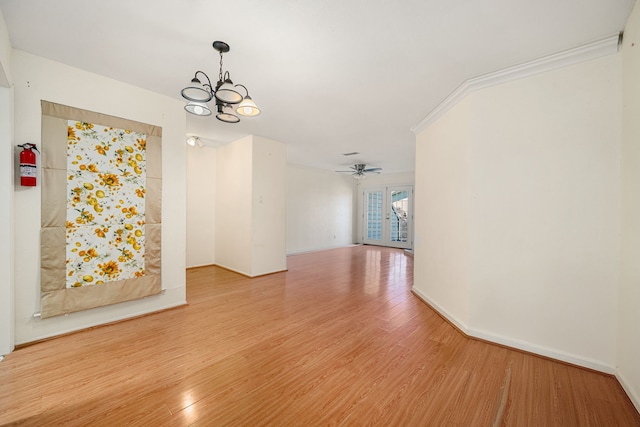 interior space with crown molding, hardwood / wood-style floors, ceiling fan with notable chandelier, and french doors