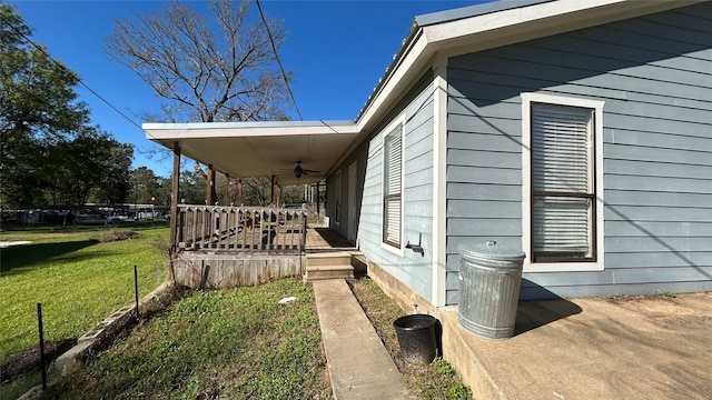 view of home's exterior with a lawn, ceiling fan, and a porch