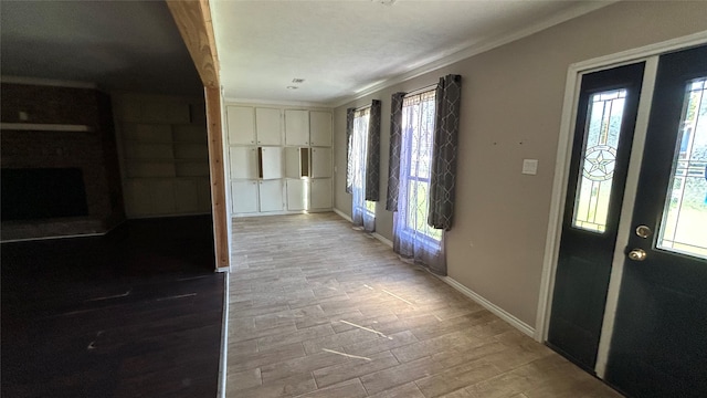 foyer entrance with light wood-type flooring and ornamental molding