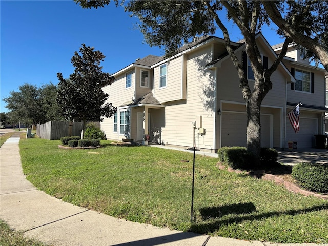 view of front of property with a garage, fence, and a front lawn