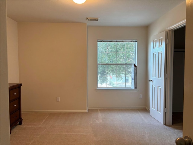 unfurnished bedroom featuring light carpet, visible vents, and baseboards