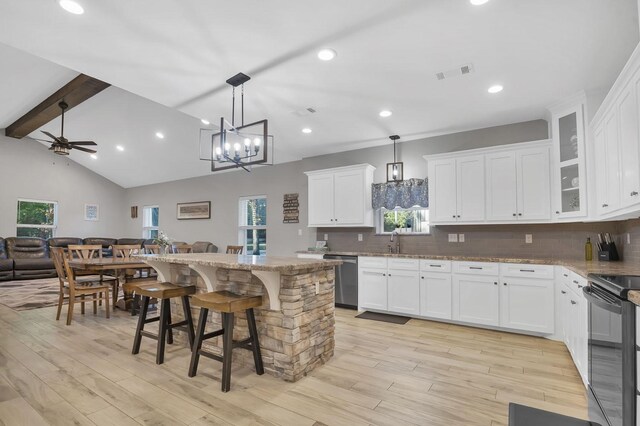 kitchen with a kitchen breakfast bar, a center island, light wood-type flooring, and white cabinetry