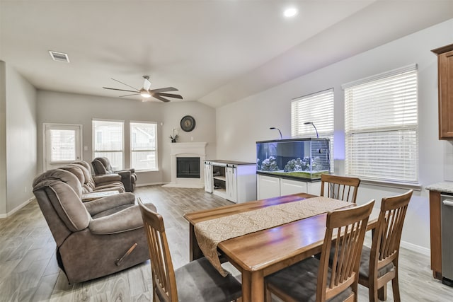 dining space featuring ceiling fan, light hardwood / wood-style flooring, and vaulted ceiling