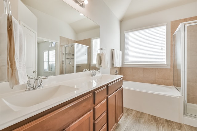 bathroom with plus walk in shower, wood-type flooring, vanity, and lofted ceiling