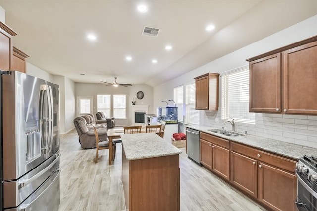 kitchen with ceiling fan, sink, a center island, appliances with stainless steel finishes, and light wood-type flooring