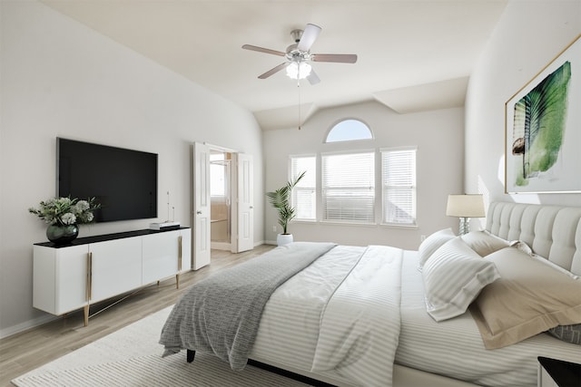 bedroom with ceiling fan, lofted ceiling, connected bathroom, and light hardwood / wood-style flooring