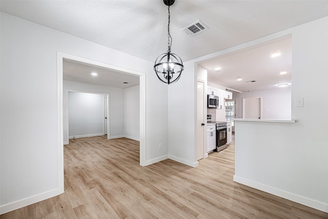 unfurnished dining area featuring light wood-type flooring and an inviting chandelier