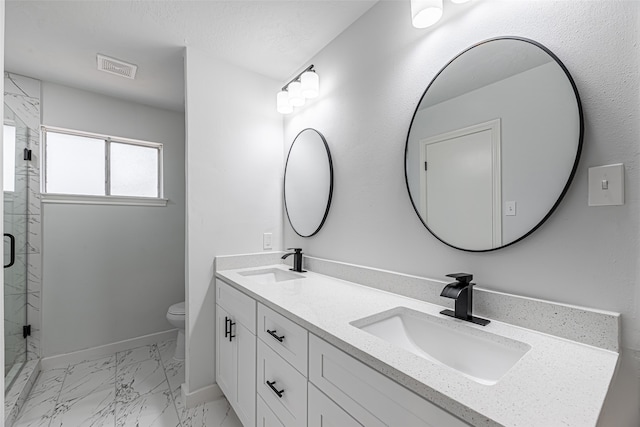 bathroom with toilet, a shower with door, and vanity