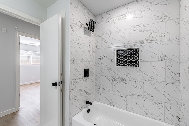 bathroom with hardwood / wood-style flooring and shower / bathtub combination