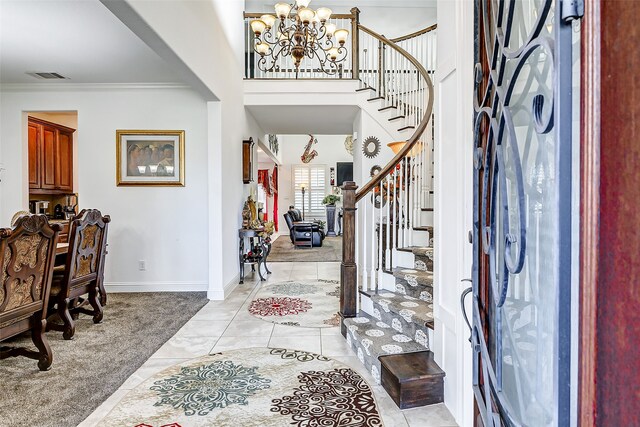 foyer featuring crown molding, light carpet, and a chandelier