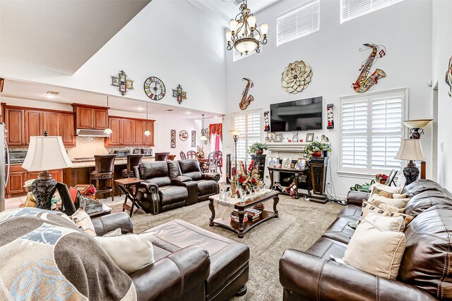 living room with a towering ceiling, a fireplace, light colored carpet, and a chandelier