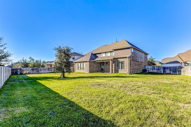 rear view of house featuring a yard