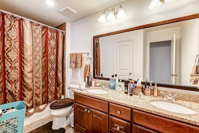 bathroom featuring toilet, vanity, and tile patterned floors