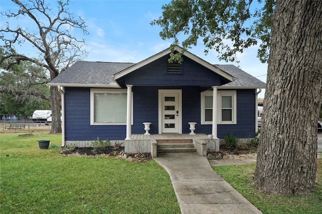 bungalow-style house featuring covered porch and a front yard