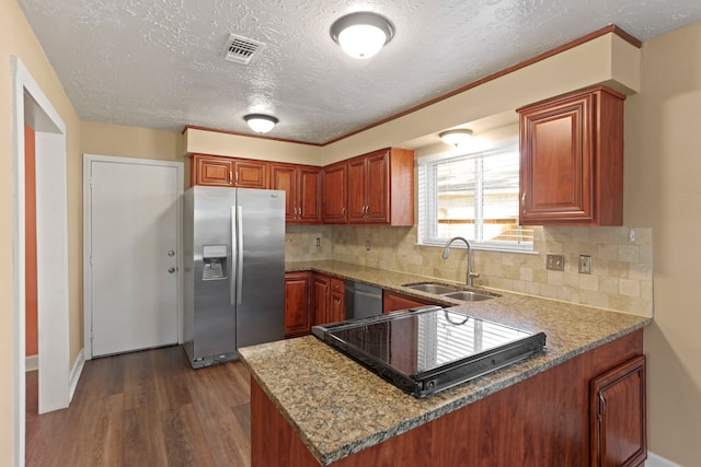 kitchen with kitchen peninsula, appliances with stainless steel finishes, dark hardwood / wood-style flooring, and sink