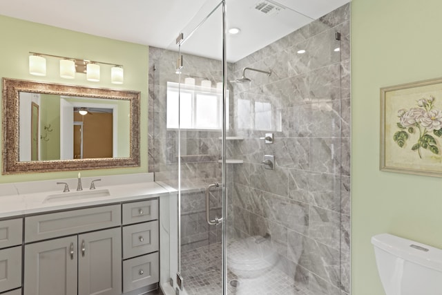 bathroom featuring vanity, toilet, and an enclosed shower