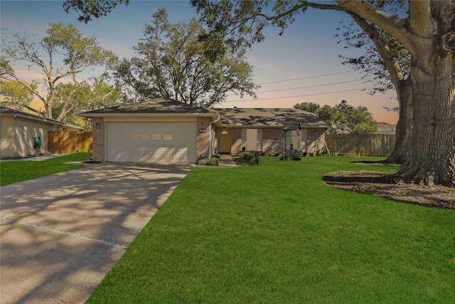 ranch-style home featuring a garage and a yard