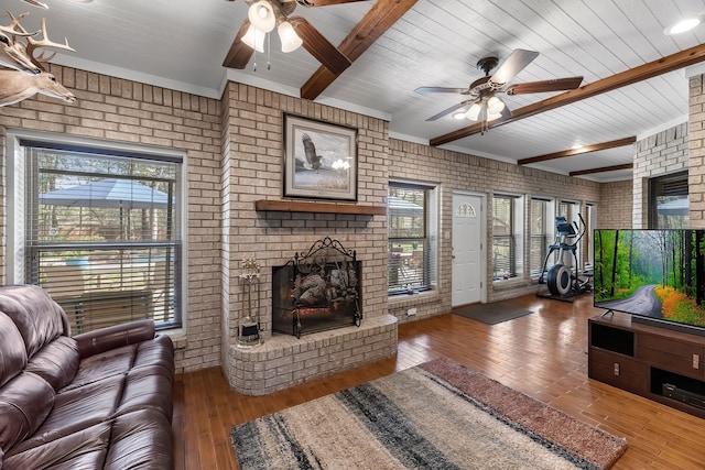 living room with a brick fireplace, beamed ceiling, brick wall, hardwood / wood-style floors, and wood ceiling