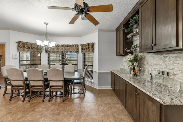 dining area with a textured ceiling, ceiling fan with notable chandelier, and ornamental molding