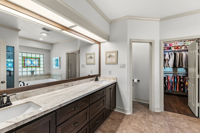 bathroom featuring tile patterned floors, crown molding, vanity, and a bath