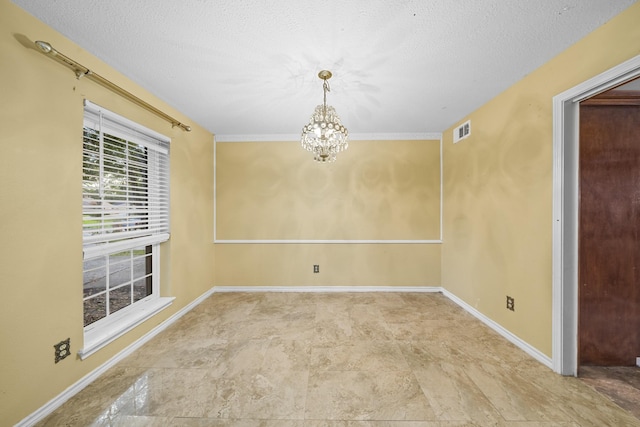 unfurnished room featuring a chandelier, a textured ceiling, and ornamental molding