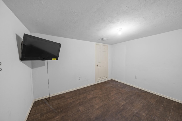 unfurnished bedroom with a textured ceiling and dark wood-type flooring