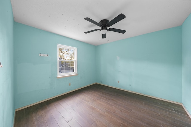 empty room featuring ceiling fan and dark hardwood / wood-style flooring