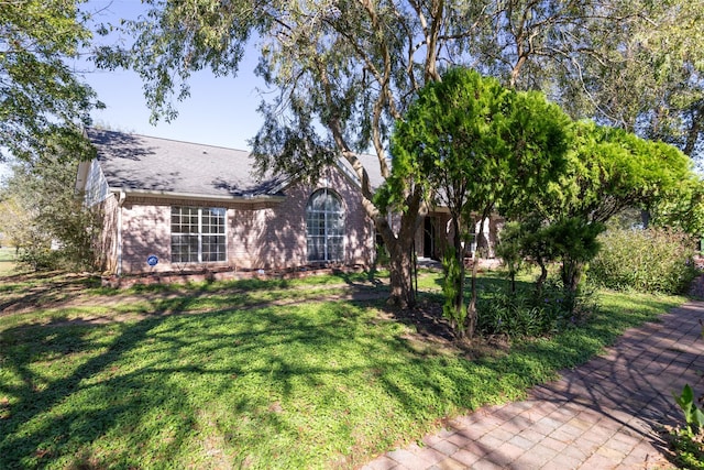16004 Penick Rd, Waller, TX 77484 - view of front facade with brick siding, a front yard, and a shingled roof