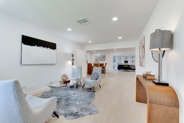 living room with wood-type flooring and built in shelves