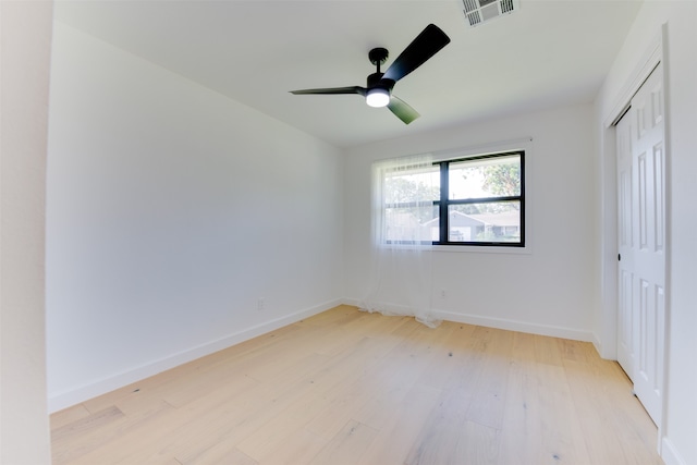 unfurnished bedroom with a closet, light hardwood / wood-style floors, and ceiling fan