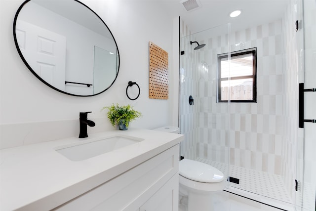 bathroom with vanity, a shower with shower door, and toilet